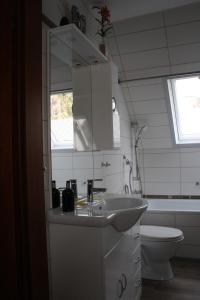 uma casa de banho com um lavatório, um WC e um espelho. em Ferienwohnung Neumann em Berlim