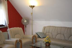 uma sala de estar com 2 sofás, uma mesa e uma ventoinha em Ferienwohnung Neumann em Berlim