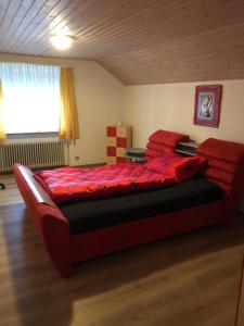 a bedroom with a large red bed in a room at Casa Wellbella in Unterkulm