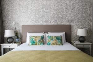 a bedroom with a bed with two night stands and two lamps at Cesca's Boutique Hotel in Xlendi