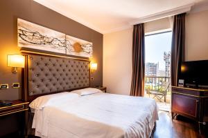 pokój hotelowy z łóżkiem i telewizorem w obiekcie Trilussa Palace Hotel Congress & Spa w Rzymie +37 zdjęć