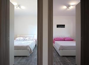 ein Schlafzimmer mit zwei Betten mit rosa Kissen in der Unterkunft *Amazing modern apartment with 2 bedrooms* in Vodnjan