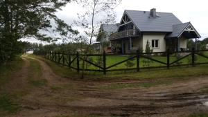 ビャウォグラにあるNiebieski domの未舗装路脇の柵付き家