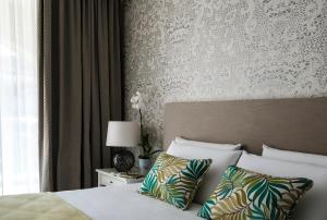 a bedroom with a bed with white sheets and pillows at Cesca's Boutique Hotel in Xlendi
