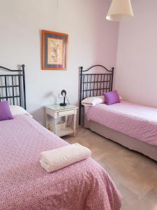 セビリアにあるApartamento Deluxe Santa Justa - Nerviónのベッドルーム1室(ベッド2台、ランプ付きテーブル付)