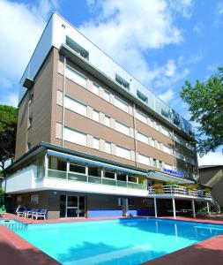 un hotel con piscina frente a un edificio en Hotel Solaria en Marina Romea