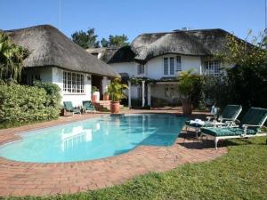 a house with a swimming pool in front of a house at Summerhill Guest Estate in Pinetown