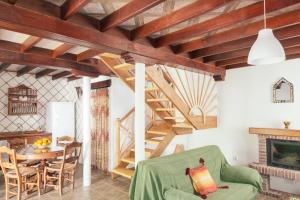 una sala de estar con techos de madera y una escalera. en Casa Lola, en Zahora