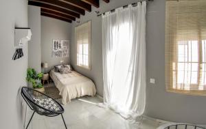 a bedroom with a bed and a window at Espectacular ático con terraza en Triana in Seville