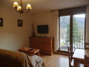 a living room with a tv and a large window at Apartamentos Casa Aneta in Sarvisé