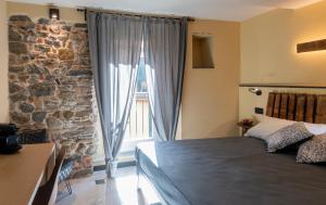 a bedroom with a stone wall and a bed and a window at Meb in Riomaggiore