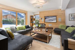 a living room with couches and a table at Chalet Montana- Chamonix All Year in Chamonix-Mont-Blanc