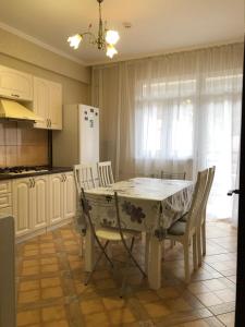 エストサドクにあるEsto-Sadok Apartment on Estonskayaのキッチン(テーブル、椅子、冷蔵庫付)