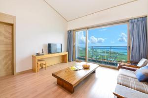 a living room with a couch and a large window at Jeju Resort in Jeju