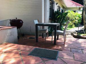 a black table and two chairs on a patio at Cottage Kilkenny in Johannesburg