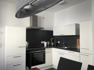 a kitchen with white cabinets and a stove top oven at Gästehaus Weingut Meierer in Kesten