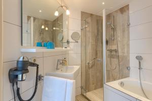 a bathroom with a shower and a sink at Hotel Op Diek in Den Hoorn +53 photos