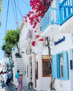 a woman walking down a street in positano with blue and white buildings at Luxury apartment in the heart of Mykonos town in Mýkonos City +15 photos