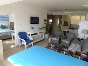 - un salon avec une table, des chaises et un lit dans l'établissement Seaview Apartment Amanzimtoti, à Amanzimtoti