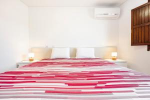 a bedroom with a large bed with a colorful blanket at Loft 1º de Maio in Tavira