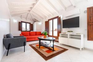 a living room with a red couch and a tv at Loft 1º de Maio in Tavira