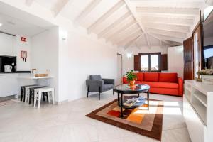 Loft 1º de Maio في تافيرا: غرفة معيشة مع أريكة حمراء وطاولة