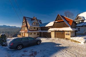 a car parked in front of a house in the snow at Zowiyrucha in Bukowina Tatrzańska