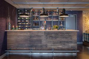 a bar with a wooden wall and a bench at Hotel Op Diek in Den Hoorn
