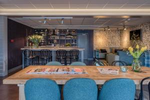 a table in a room with chairs and a bar at Hotel Op Diek in Den Hoorn