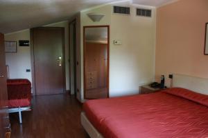 una camera con letto rosso e pavimento in legno di Parc Hotel Casa Mia a Lazise