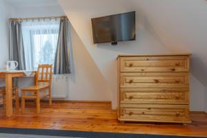 ein Schlafzimmer mit einer Holzkommode und einem Esszimmer in der Unterkunft Zowiyrucha -100 m do wyciągów narciarskich i 900 m do term in Bukowina Tatrzańska
