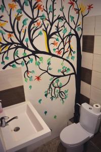 a bathroom with a tree and birds on the wall at Kaunas Homestay in Kaunas +44 photos