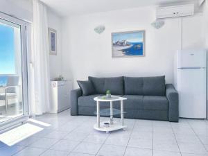 a living room with a blue couch and a table at Beach Apartments Tina in Rogoznica