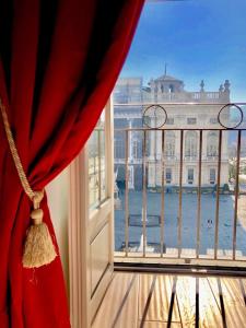 a window with a red curtain and a view of a building at Corte Realdi Luxury Rooms Torino in Turin