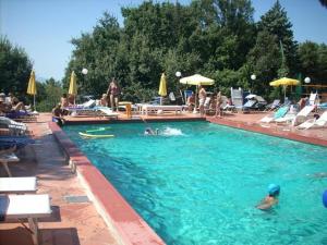 a swimming pool with people in the water at Castello di Trisobbio in Trisobbio