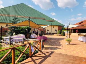 un chapiteau avec des tables et des chaises devant un bâtiment dans l'établissement Villa Audruvis, à Joniškis