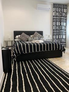 a black bed with a black and white striped rug in a bedroom at Di Palma Suite Museum in Naples