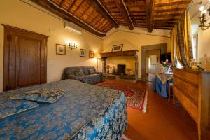 a bedroom with a bed and a chair in a room at Villa Borgo San Pietro in Cortona
