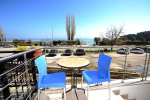 a table and chairs on a balcony with a view of a parking lot at Thalia Premium Apartment in Kavála