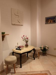 una mesa con sillas y un jarrón de flores. en Apartments Ivona 2, en Trogir