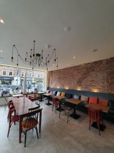 a restaurant with tables and chairs and a brick wall at Hotel Heye 130 in Amsterdam