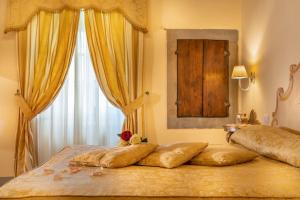 a bedroom with two beds with yellow curtains and a window at Villa Borgo San Pietro in Cortona