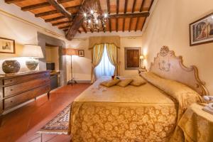 a bedroom with a large bed and a dresser at Villa Borgo San Pietro in Cortona
