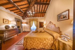 a bedroom with a large bed and a wooden ceiling at Villa Borgo San Pietro in Cortona