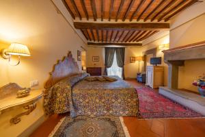 a bedroom with a bed and a fireplace at Villa Borgo San Pietro in Cortona
