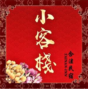 um cartão vermelho com escrita chinesa e flores nele em Tainan-Inn em Tainan