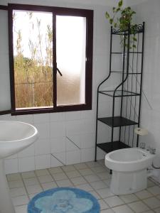 a bathroom with a sink and a toilet and a window at la maddalena in La Maddalena