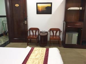 a bedroom with two chairs and a bed and a table at Yen Phu Hotel in Tuy Hoa