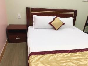 een bed in een hotelkamer met een kussen erop bij Yen Phu Hotel in Tuy Hoa