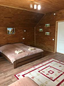a bedroom with a bed in a room with a rug at ‘‘FOREST HOUSE ’‘ Будинок для відпочинку in Truskavets